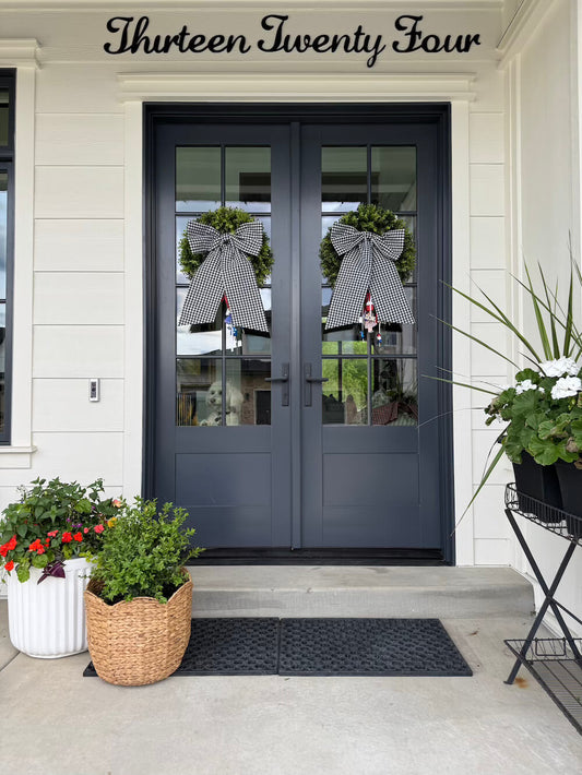 Black gingham decorative bows on wreaths with porch flowers