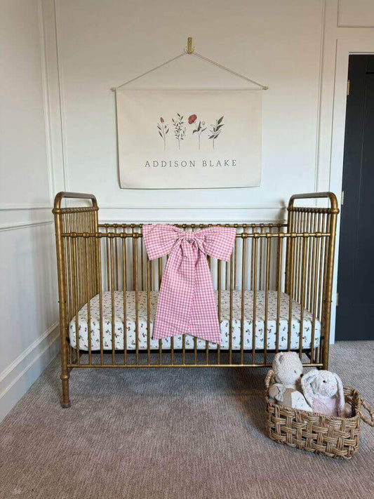 Pink gingham bow on nursery crib
