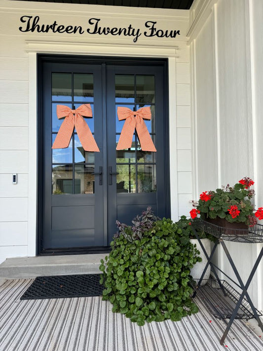 Orange front door bows on double front doors with greenery
