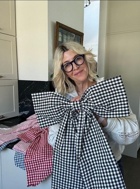 Jeneil holding a black gingham bow