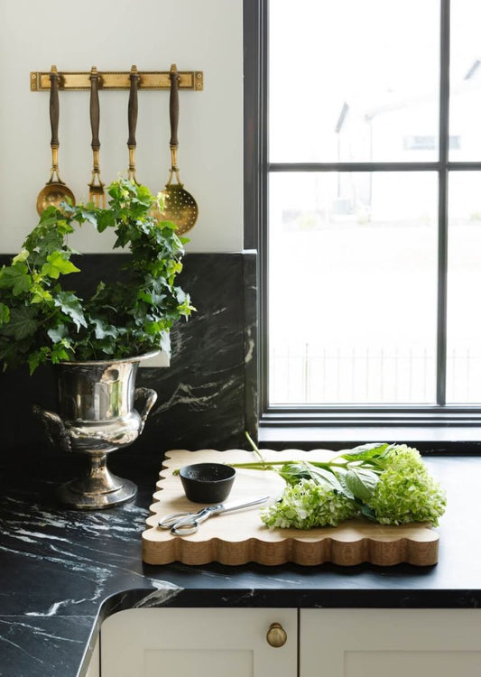 Oak cutting board on dark countertop