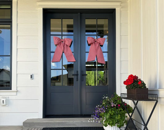 Two red decorative gingham bows on double front doors