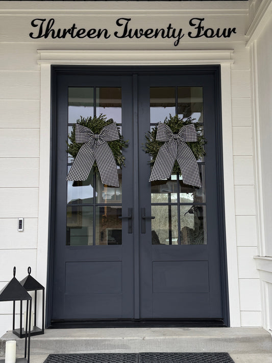 Two black gingham bows hanging on front door 