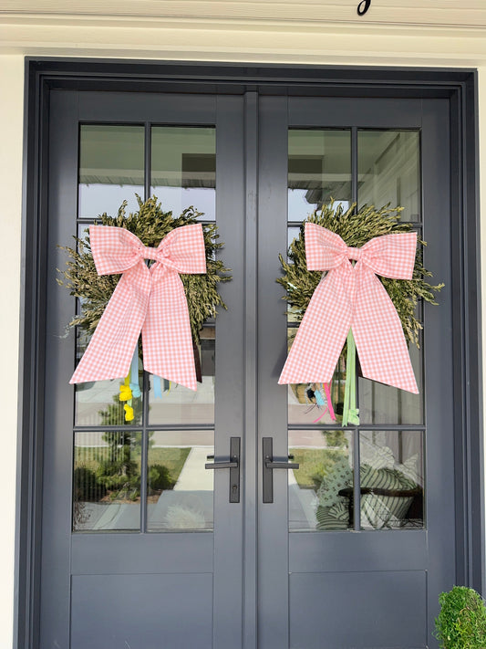 Light pink front door bows on a set of double doors, with wreaths and Easter ribbons