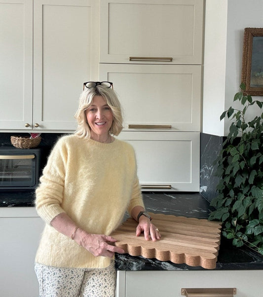 Jeneil poses in her kitchen with her scalloped oak cutting board