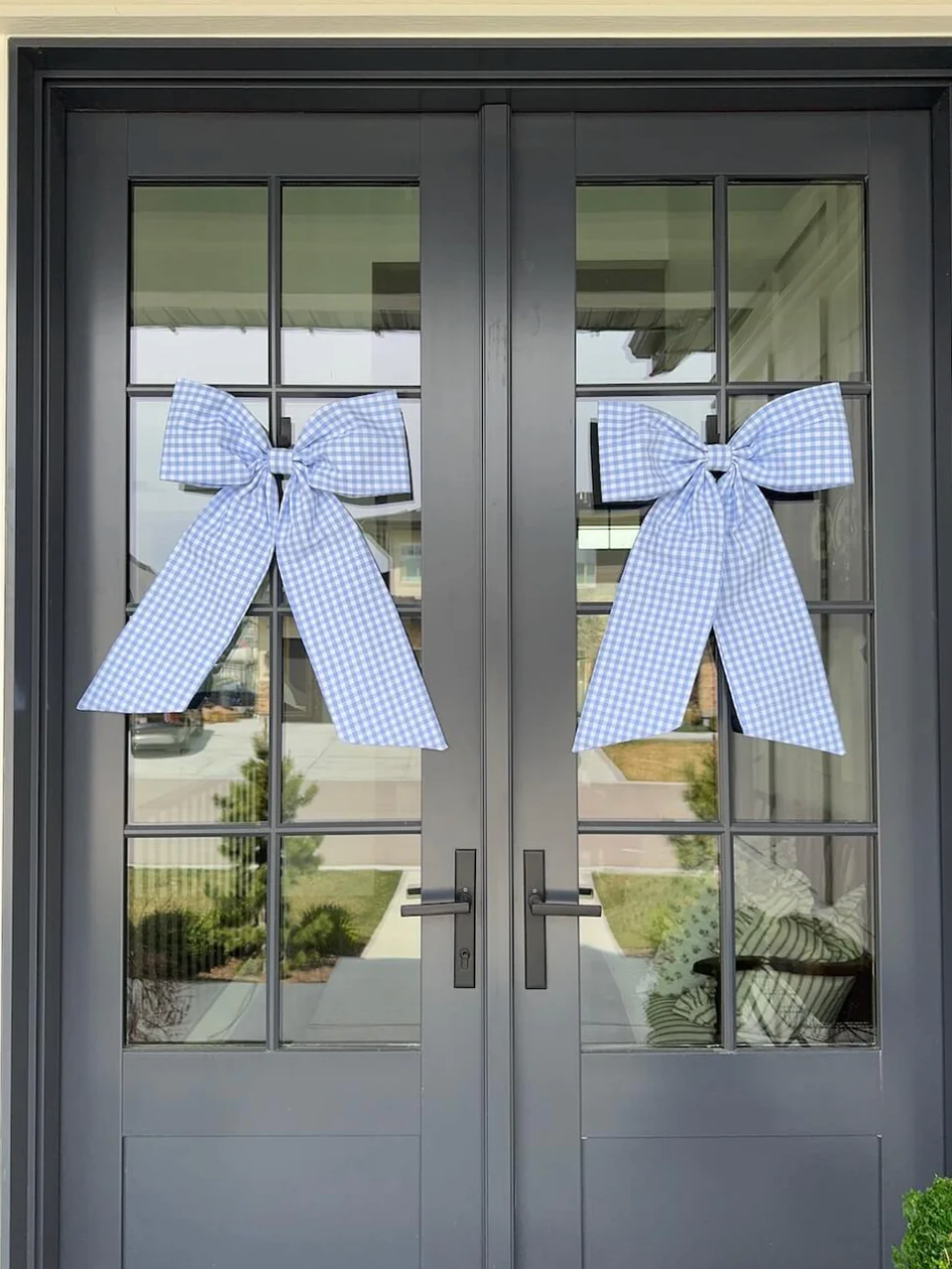 Two baby blue gingham bows hanging on front door