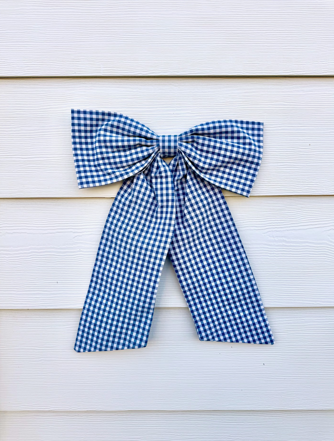 Blue gingham bow against a cream background 